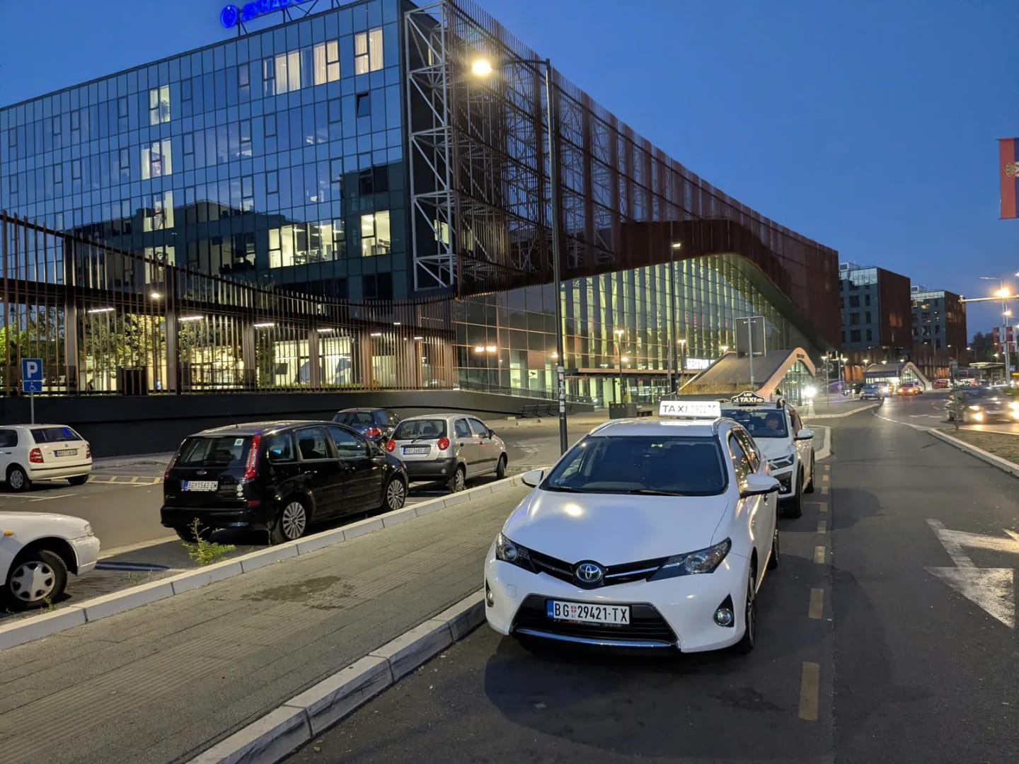 Beli Toyota Auris taxi ispred poslovnog kompleksa Hajd park kod Prokopa